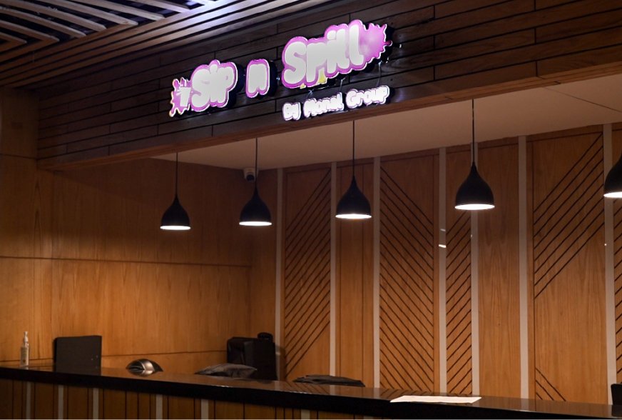 The Sip & Spill counter under its neon sign