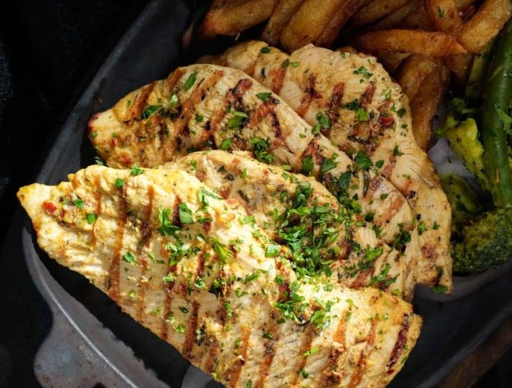 Grilled chicken with fries on a Monal sizzler