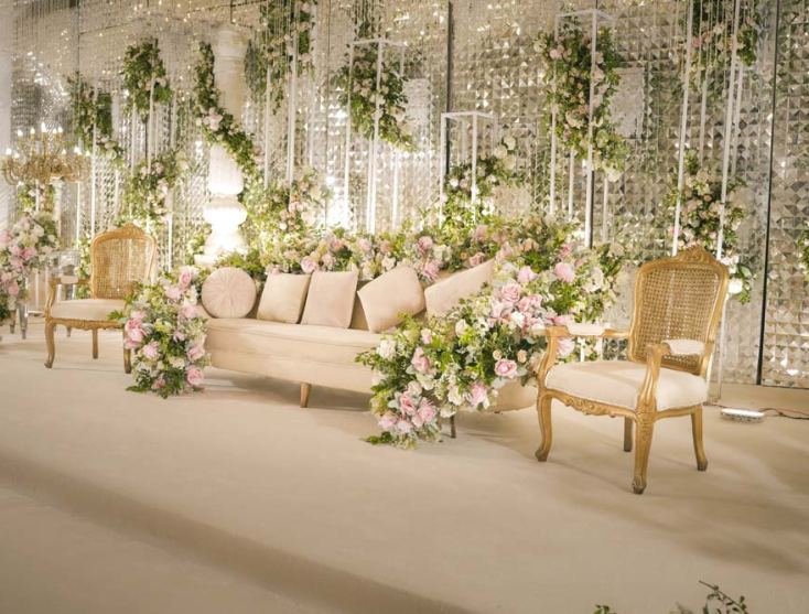 A floral stage with gold seating at a Monal Marquee