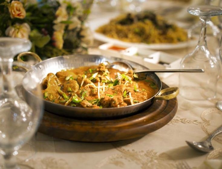 Catered dishes on a dressed table by Monal Caterers & Event Managers