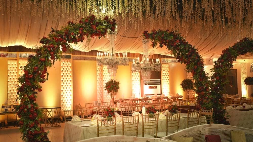 Illuminated floral arches inside a Monal Marquee event hall